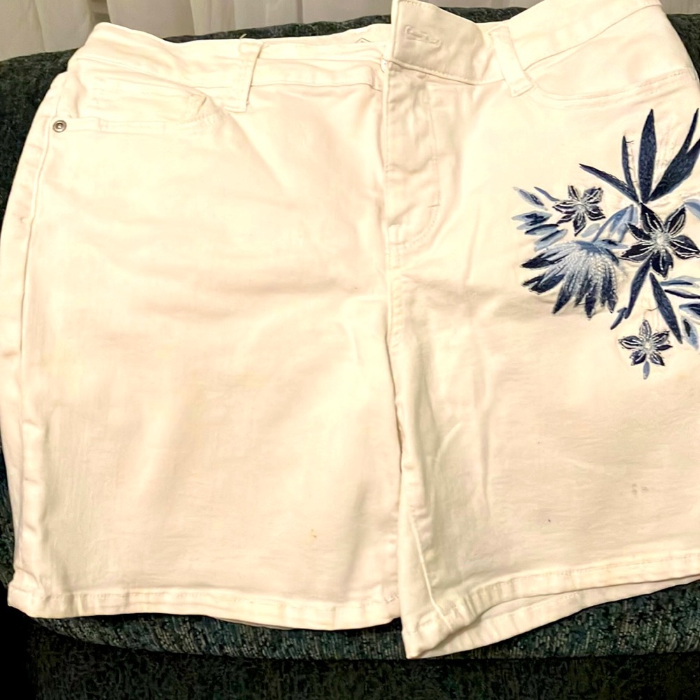 Ladies white shorts with blue flowers under a pocket and another on back pocket